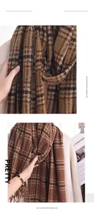 Makro-Detail von kariertem Kaschmir-Imitat-Schal mit weichen Fransen und warmer Textur