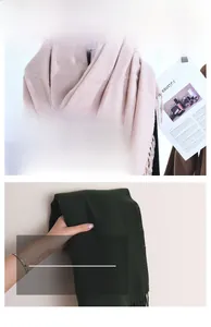 Close-up showing the soft texture and tassel detail of pink and green cashmere scarves