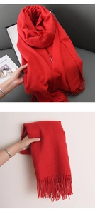 Close-up of soft red cashmere-feel scarf with detailed knitting texture and tassels