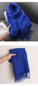 Detailed texture of royal blue cashmere-feel scarf with matching tassels for winter