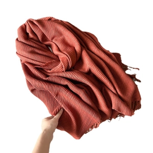 Caramel pleated cashmere-feel scarf with elegant fringe trim and soft draped texture