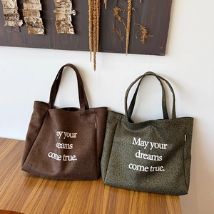 Detail of leopard print suede tote bag featuring white printed inspirational quote