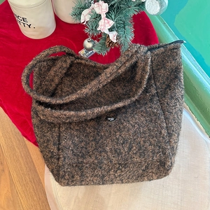 Détail macro du sac cabas en peluche marron foncé avec anse noire et fermeture éclair