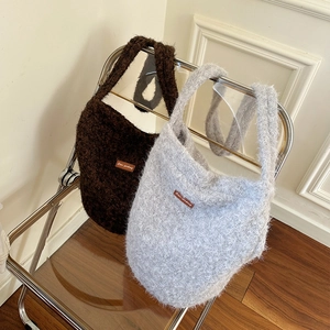 Detailed plush tote bag textures in dark brown and light grey on a modern folding chair