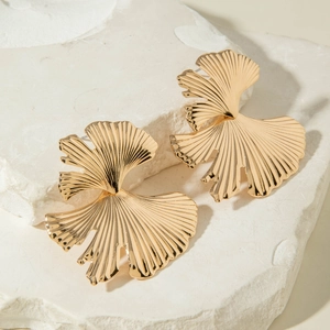 Détails de boucles d'oreilles vintage dorées en forme d'éventail sur pierres blanches