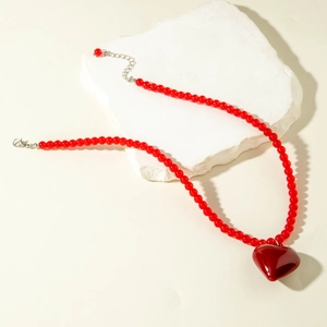 Collier rétro à perles rouges avec pendentif cœur sur fond de pierre naturelle