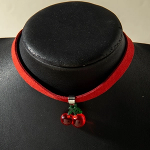 Vue macro détaillée du collier choker en velours rouge avec pendentif cerise et feuilles vertes