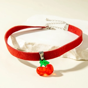 Détail du collier cerise rouge avec cordon en daim et feuilles vertes sur pierre