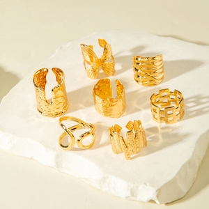 Detail view of 7-piece gold hollow butterfly and irregular textured ring set on stone