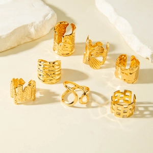 Set of 7 gold hollow rings with irregular lines and geometric textures on stone