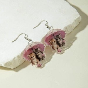 Detail von Acryl-Katzenohrringen mit süßem rosa Regenschirm und künstlerischem Kätzchendesign