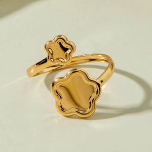 Macro detail of high-polish gold flower rings with sleek floral and leaf metal patterns