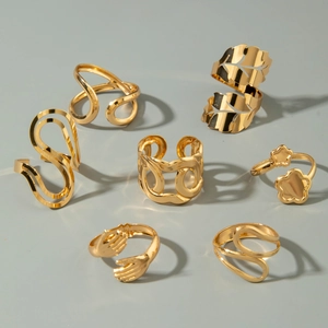 Golden ring set featuring hollow leaf, abstract flow, flower, and hugging hand designs
