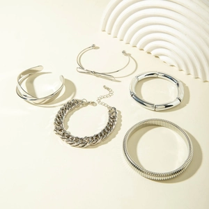 Detail of five-piece silver metal bracelet set with bow cuff and chunky chain design