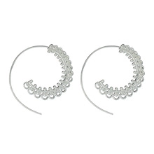 Detailed close-up of silver leaf spiral hoop earrings with intricate lace metalwork