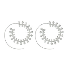 Detail view of silver spiral leaf earrings with beaded inner edges on a white background