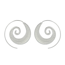 Macro detail of silver spiral leaf earrings with intricate feather engraved textures