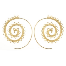 Detailed view of spiral gold-toned leaf earrings with bohemian cutout patterns