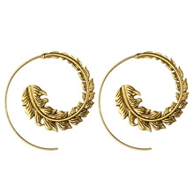 Detailed view of spiral leaf earrings featuring intricate golden feather textures