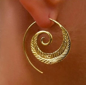 Golden spiral drop earrings with feather texture and crystal detail on ear model