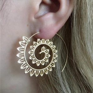 Detailed close-up of golden spiral leaf earrings with intricate openwork patterns