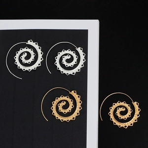 Detailed view of spiral hoop earrings in gold and silver with vintage geometric patterns