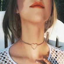 Detail of gold heart pendant choker with mixed chain textures shown on a neck