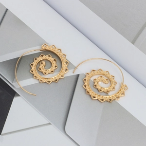Detailed close-up of golden spiral earrings featuring hollow mandala pattern design