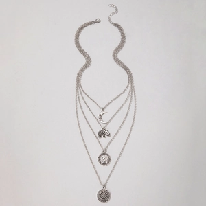 Detail of silver layered necklace with moon, elephant, Om and celestial disc pendants