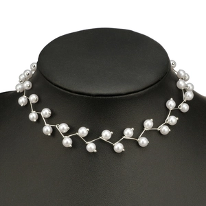 Detailansicht der weißen Rundperlen auf einem silbernen Wellen-Choker auf einem Halsmodell
