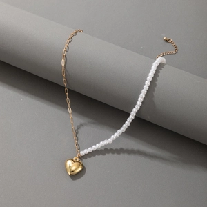 Detail einer Herz-Halskette mit weißen Perlen und goldener Metallglieder-Kette