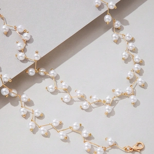 Makro-Detailansicht einer eleganten Perlenkette mit goldenen Gliedern und Karabiner