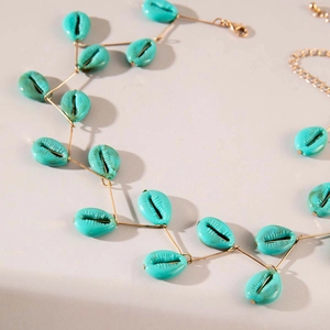 Detailaufnahme der böhmischen Muschelkette in Türkis mit goldenen Gliedern auf neutralem Grund
