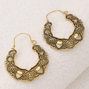 Detail of vintage gold hollow heart pattern earrings with intricate lace metalwork