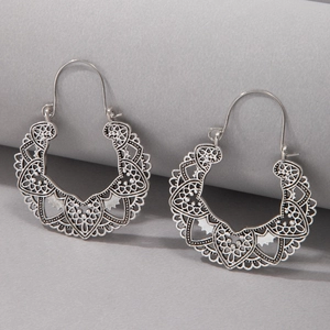 Detailed close-up of vintage hollowed heart and floral pattern earrings with matte finish