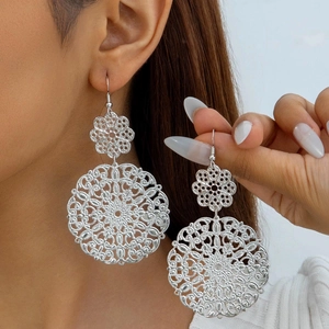 Close-up of bohemian hollow mandala silver earrings with intricate geometric pattern