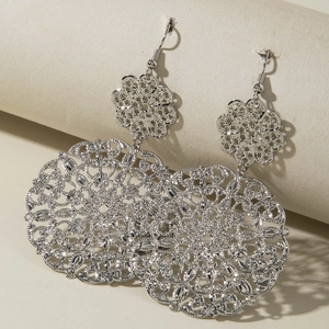 Detail of silver hollow mandala earrings featuring intricate bohemian geometric patterns