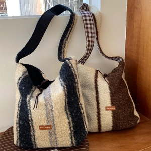 Detail of lamb wool plaid tote bag showing wide straps and Star-picking leather patch