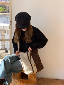 Detailed view of striped lamb wool tote bag with soft texture and leather logo patch