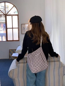 French retro style large brown and white checkered canvas tote bag worn by a model