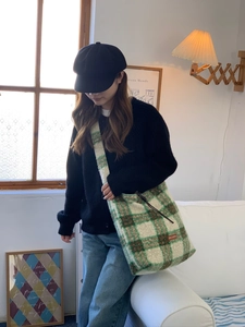 Detail of the cozy plaid lamb wool tote bag featuring a green and brown checkered pattern