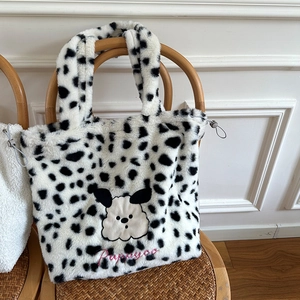 Detail of plush tote bag with leopard spots, puppy embroidery and drawstring closure