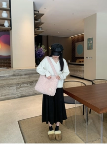 Gros plan sur le sac fourre-tout en polaire rose avec texture douce et bandoulière large