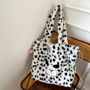 Detail of plush tote bag with cow print pattern and cute puppy embroidery on soft faux fur