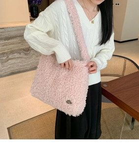 Vue détaillée du sac cabas en polaire rose avec étiquette en métal et bandoulière