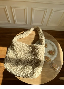 Gros plan du sac cabas en peau de mouton synthétique crème avec une texture polaire douce