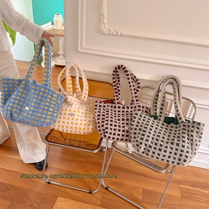 Macro view of plush checkered tote bags showing thick fleece texture and various colors