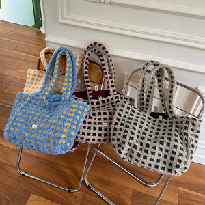 Close-up of plush checkered tote bags in blue, brown, and green thick faux shearling fabric