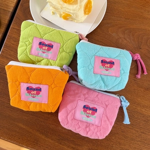 Dettaglio di mini pochette in cotone trapuntato in colori pastello con ricamo a cuore