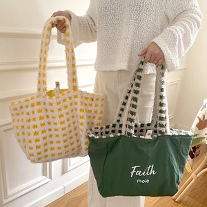 Close-up of plush checkerboard tote bags with fuzzy texture and snap button closure